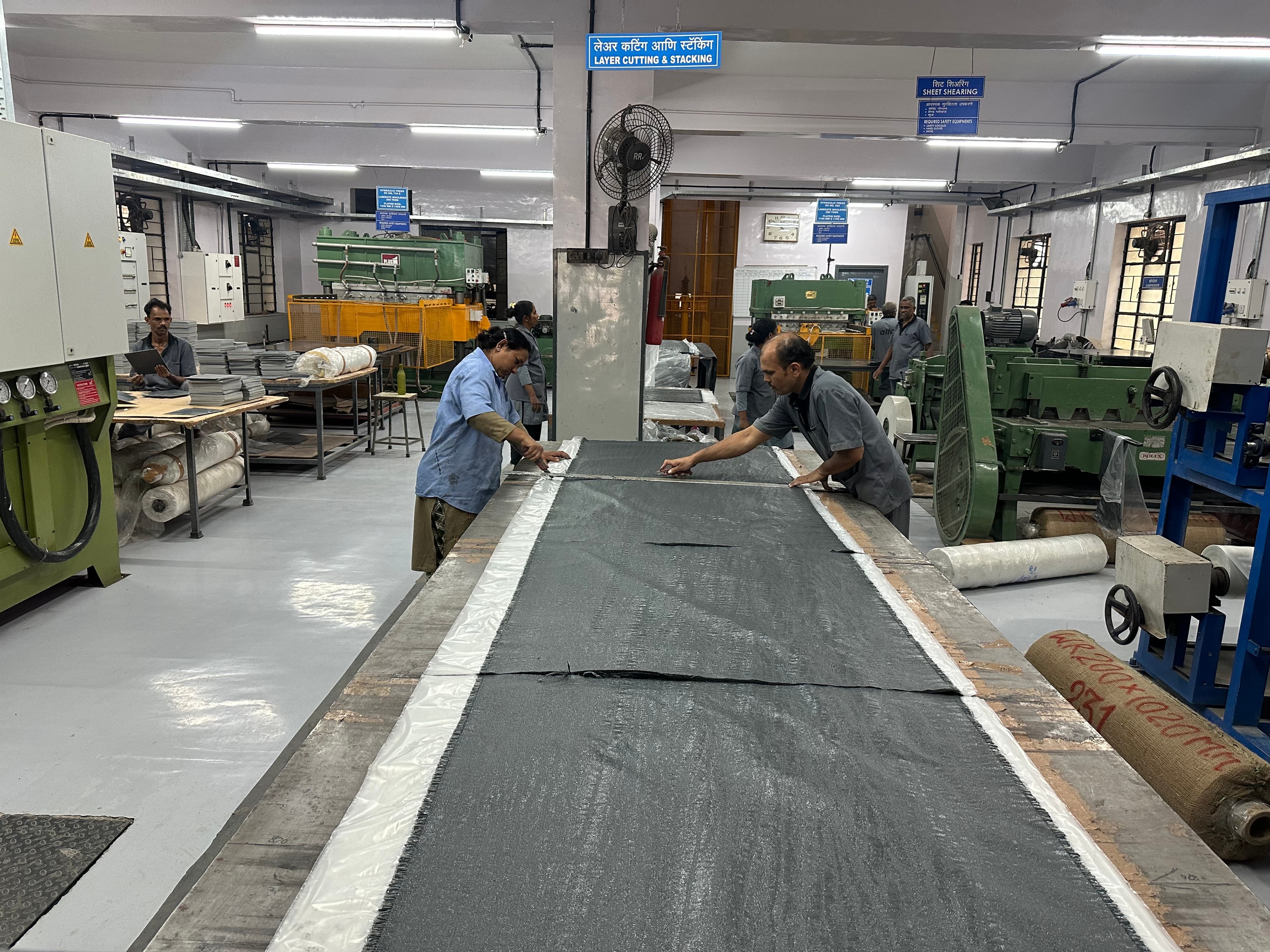 Layer cutting and stacking station — preparing fibreglass layers for lamination
